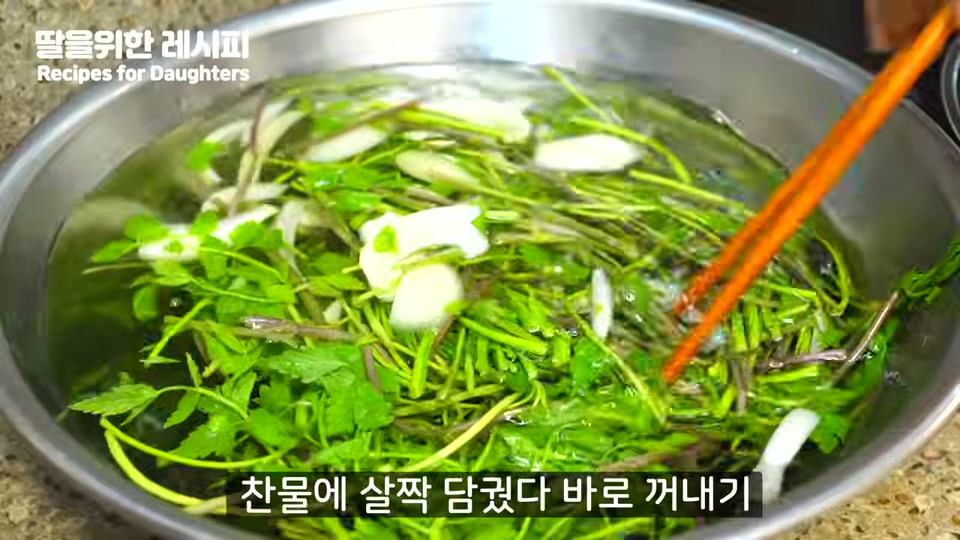 데친 미나리를 찬물에 헹구는 장면