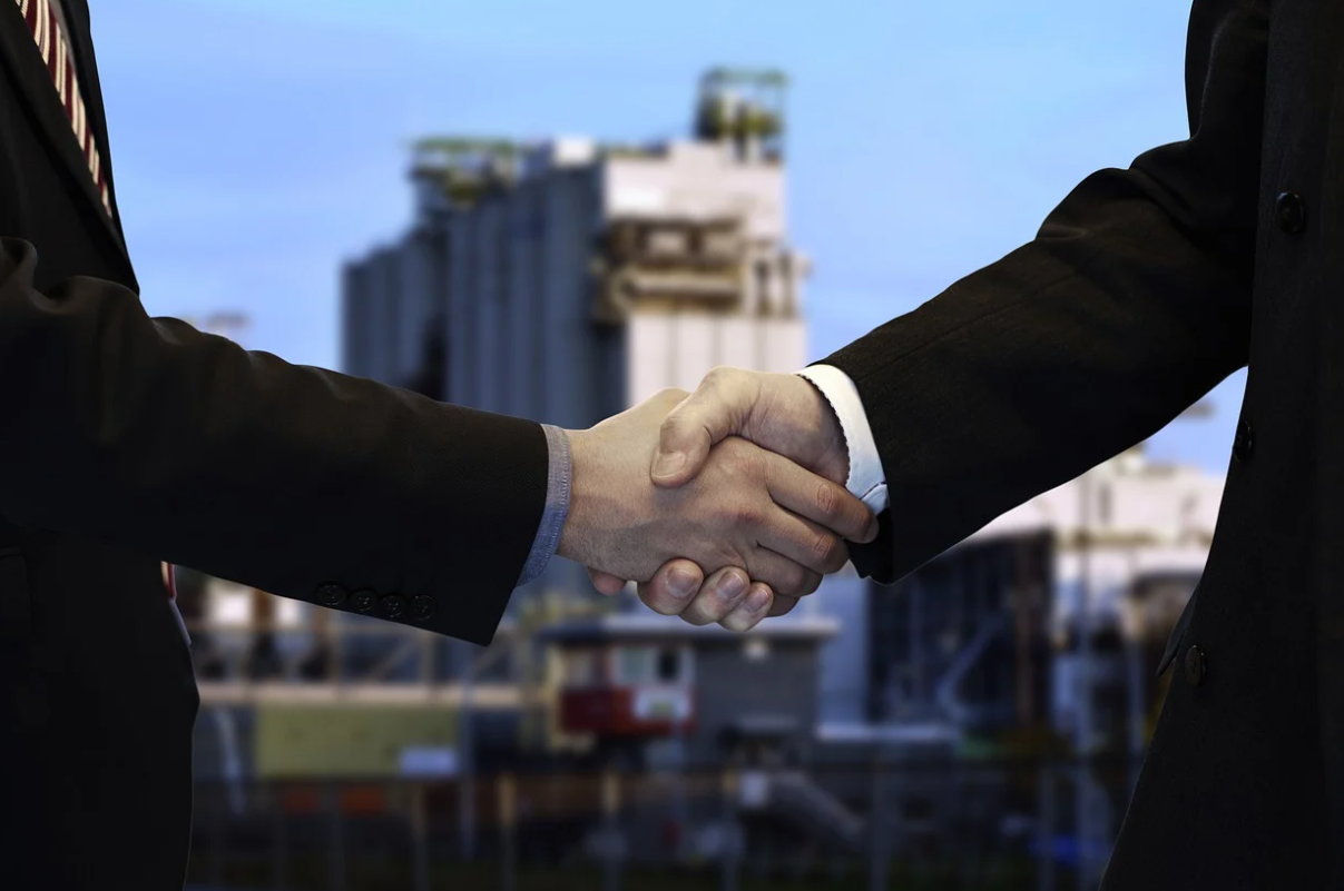 도시를 배경으로 악수하는 두 사람