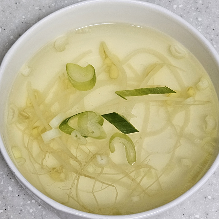 시원한 국물에 콩나물과 파가 들어간 콩나물 냉국이 그릇에 담긴 모습