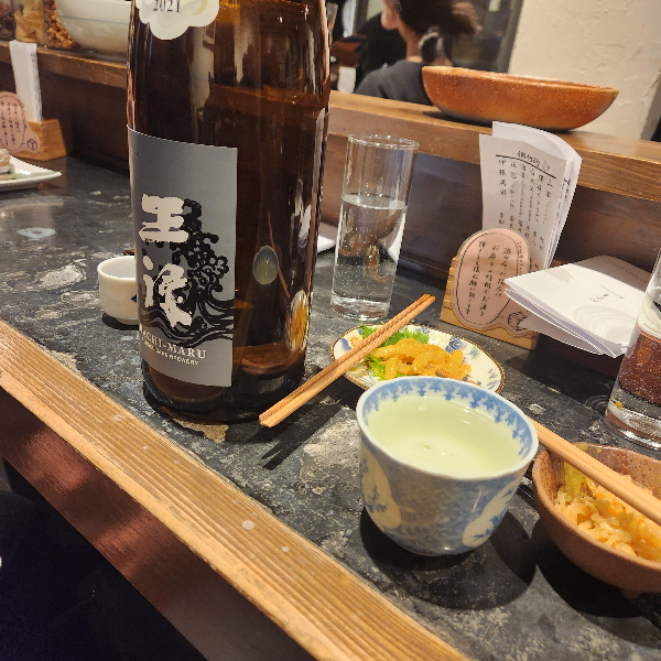 갈색 사케병과 도자기로 된 사케잔이 놓여있다.