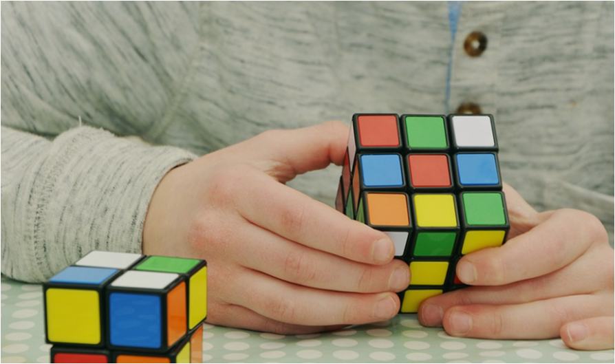 집중해서-큐브를-맞추고-있는-사람의-손