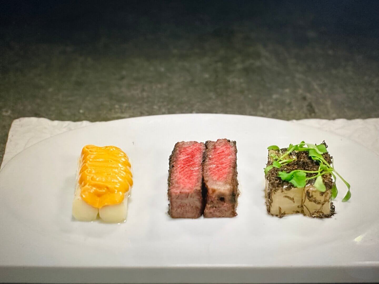 스테이크와 야채 요리가 흰 접시에 담긴 모습