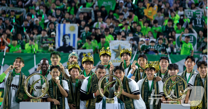 2025년 K리그1 우승 트로피를 들고 환호하는 전북 현대 거스 포옛 감독의 모습. 그의 얼굴에는 우승의 기쁨과 함께 깊은 고민이 담겨 있다.