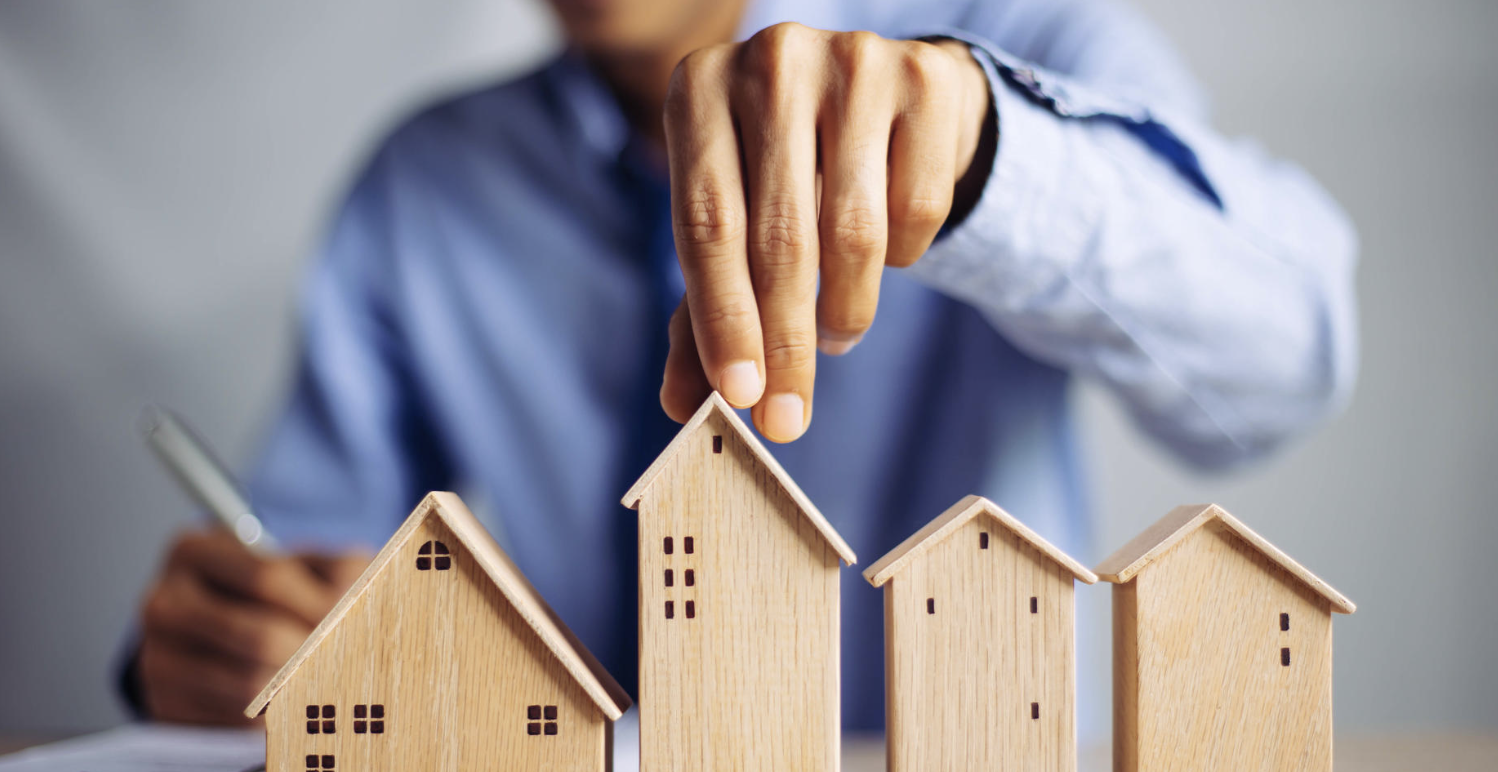 모형 집을 만지고 있는 남자의 모습