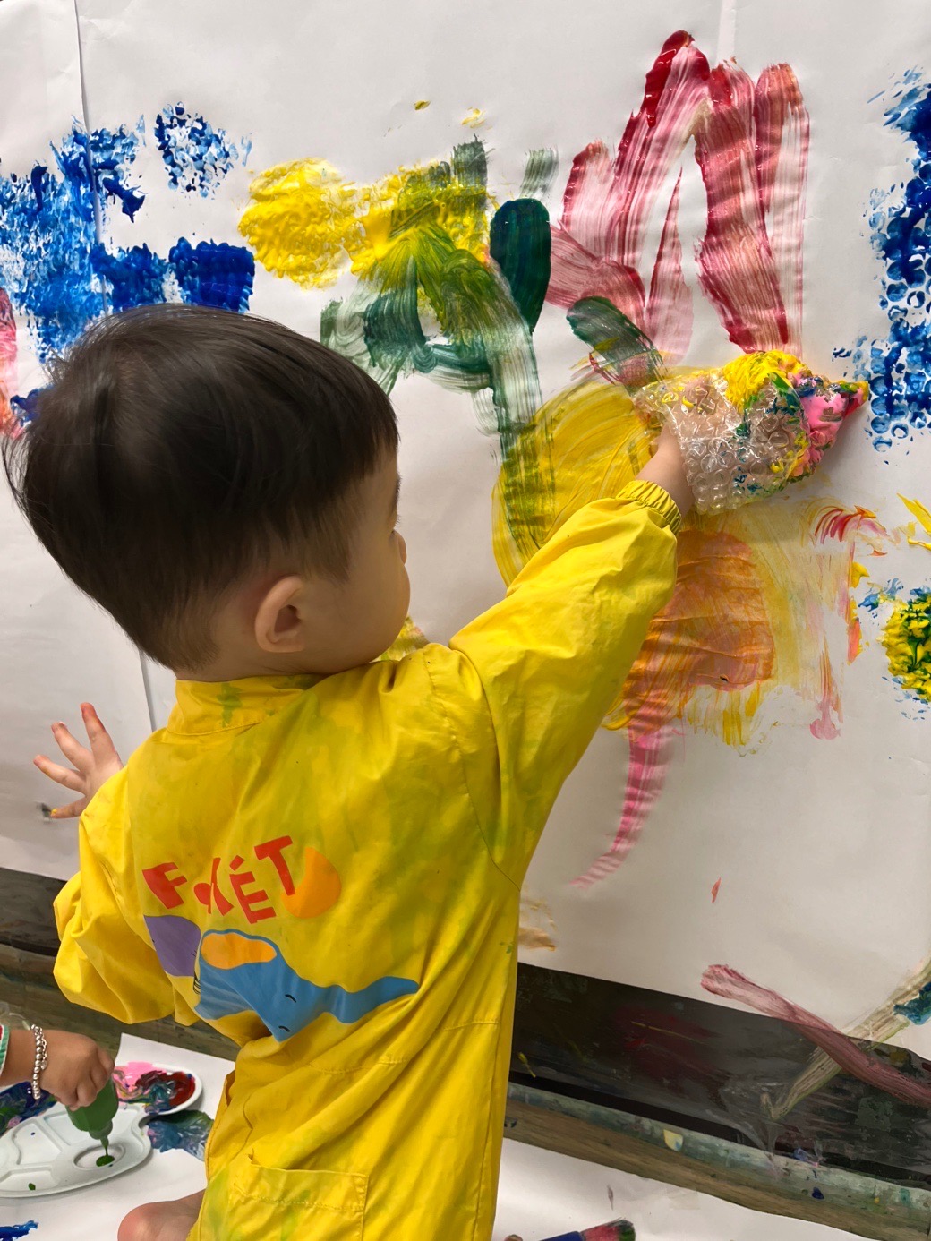 아기가 미술수업 받고 있는 사진