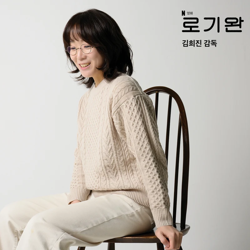 안경을 쓰고 의자에 앉아 있는 김희진 감독