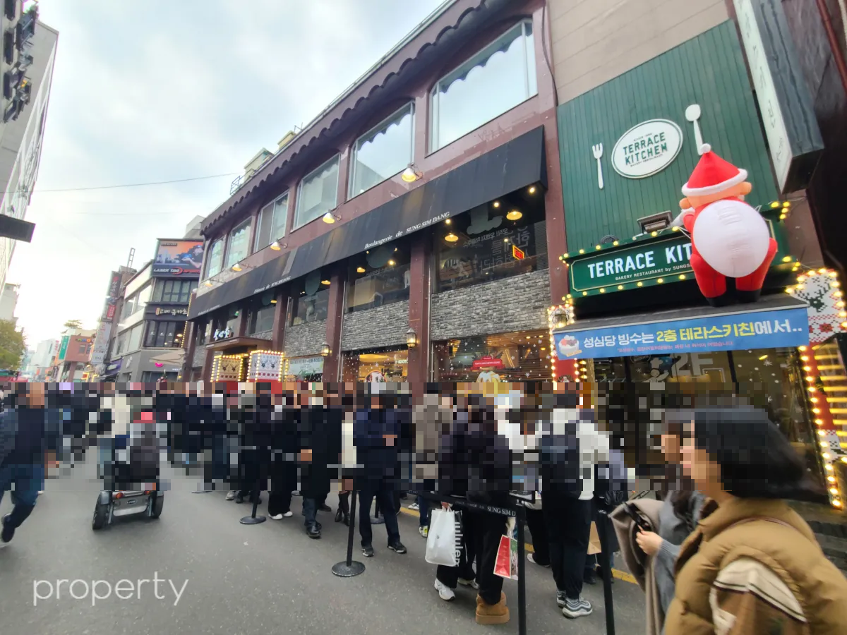 성심당본점건물-앞에줄선사람들-초록색간판의테라스키친-흰색포크와숟가락그림이그려져있는-커다란산타풍선도매달려있다