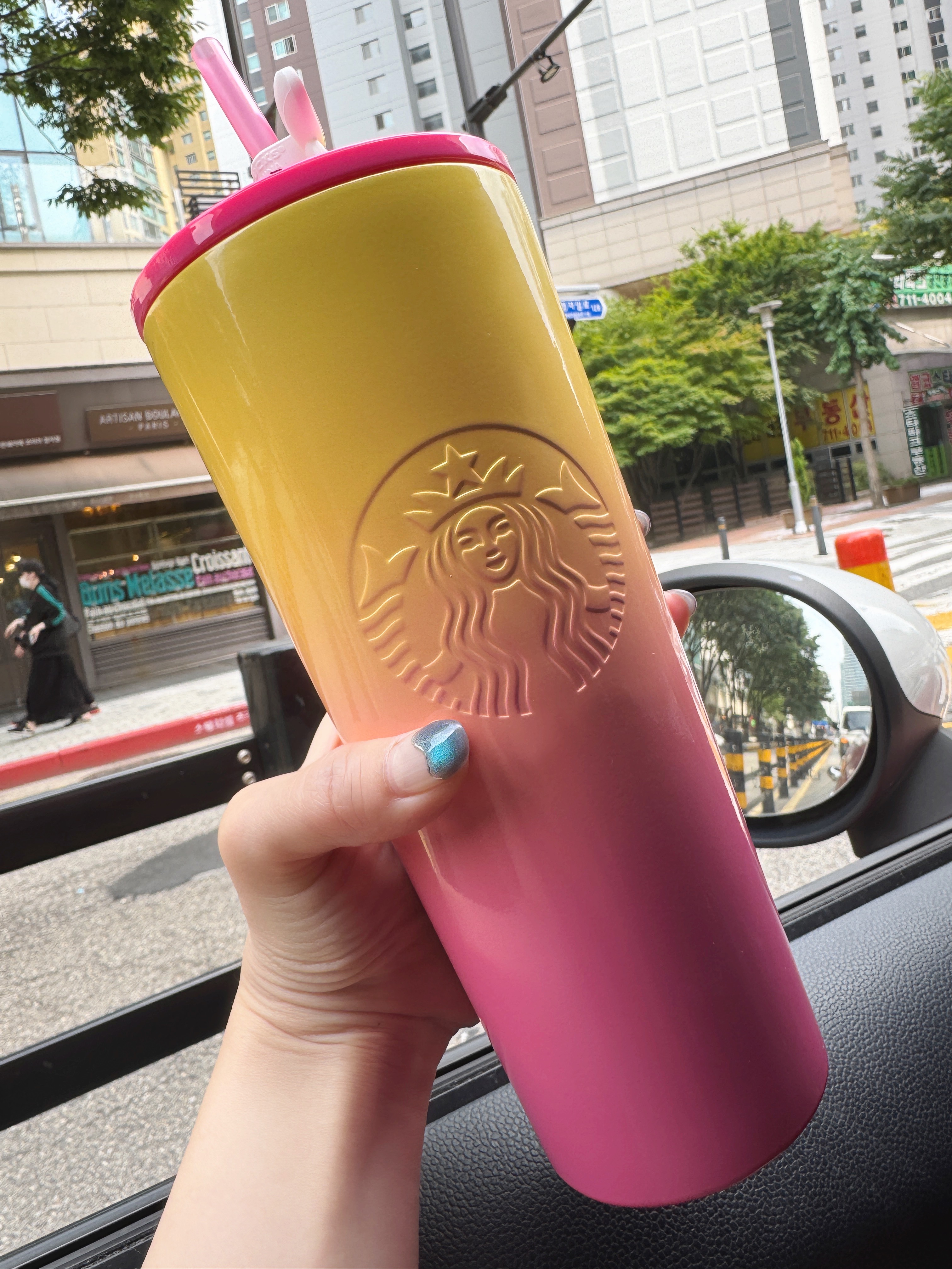 운전 중 차 안에서 스타벅스 텀블러를 들고 있는 사진