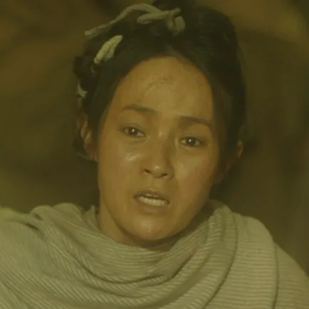 40대 여성이 천으로 머리를 꼬아 말아올리고 회색 옷을 입고 있는 아라문의 검 여상 캐릭터