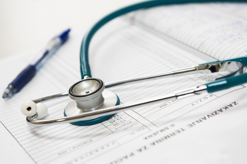 "의료 차트 위에 청진기와 볼펜이 놓인 모습, 임신 중 산전 검사와 기형아 검사 과정을 상징하는 이미지"