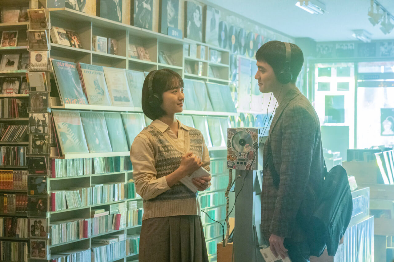 CD 플레이어 앞에서 음악을 감상하고 있는 남자와 여자