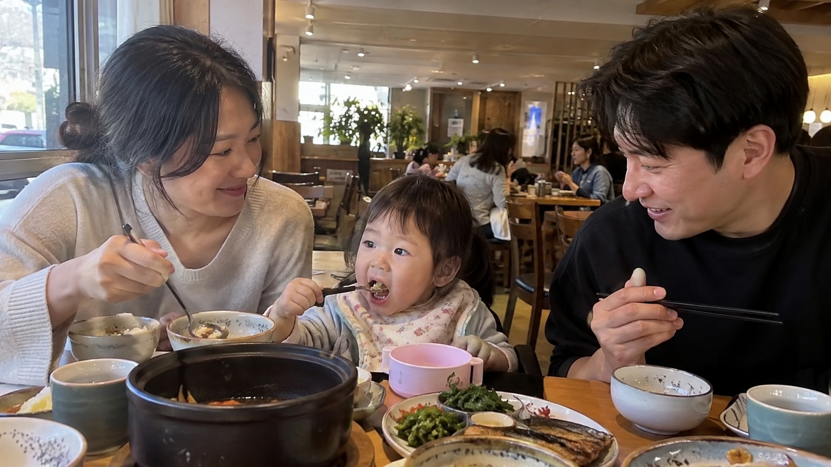 가족 동반 자리에서 아이와 함께 앉아 있는 부부