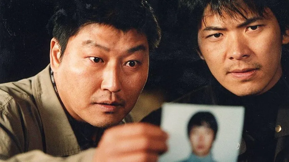 두명의 주인공이 용의자사진을 보고있는 모습