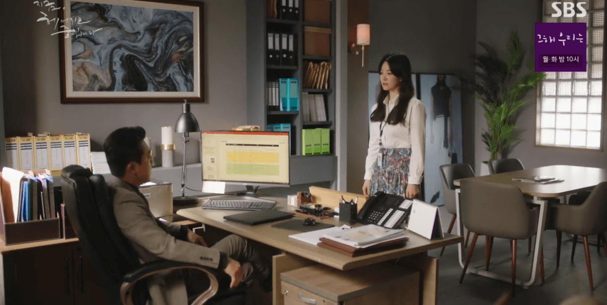 하영은이 잉크 셔츠드레스와 스커트를 입고 본부장과 얘기하고 있음