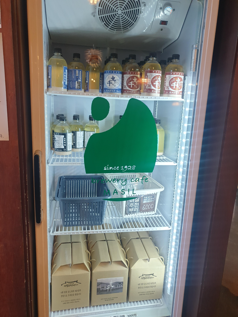 냉장고 안에 4종 막걸리가 보인다. 파란색, 빨간색, 검은색, 초록색 라벨로 구분된다.