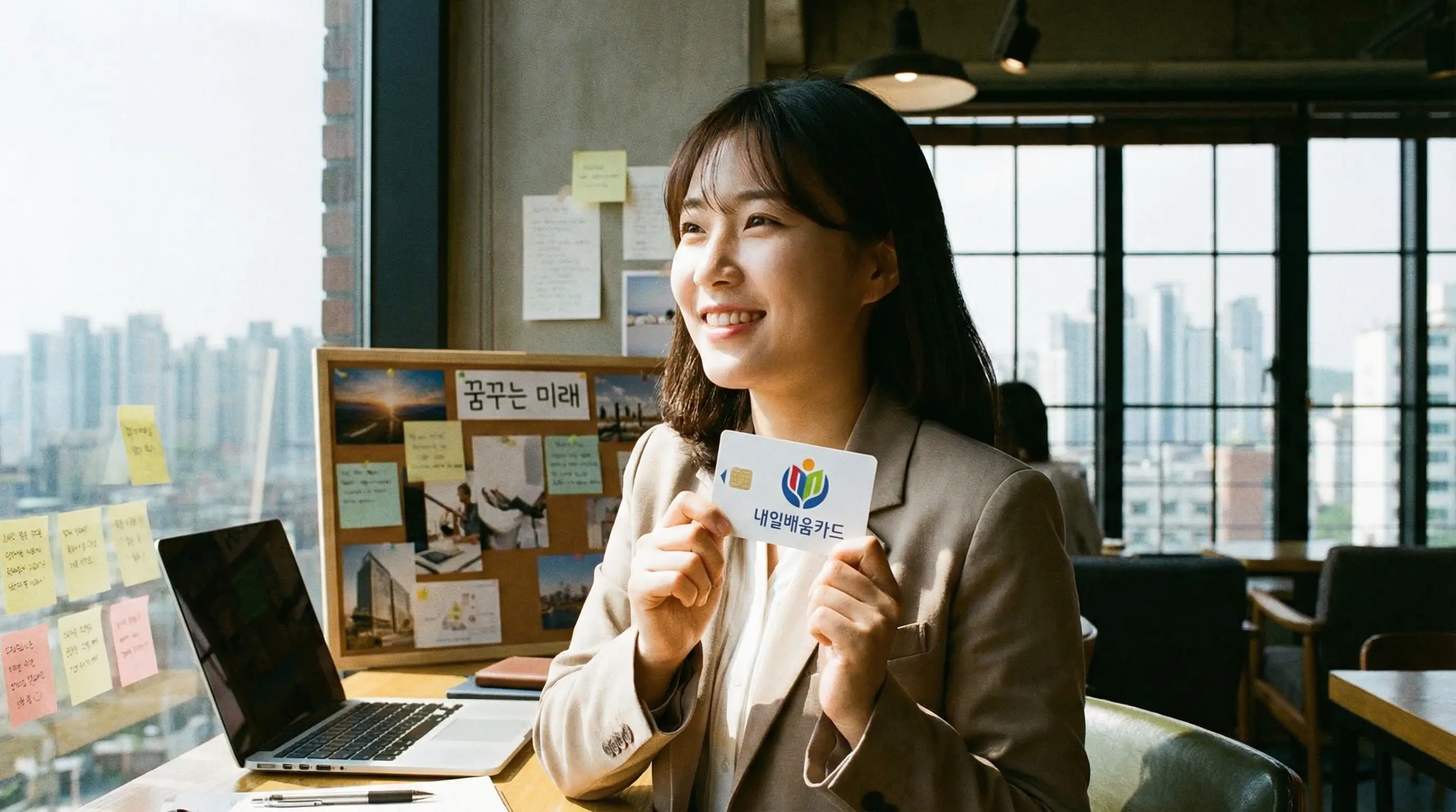 내일배움카드를 손에 들고 환하게 웃으며 미래를 꿈꾸는 취업 준비생의 자신감 넘치는 모습