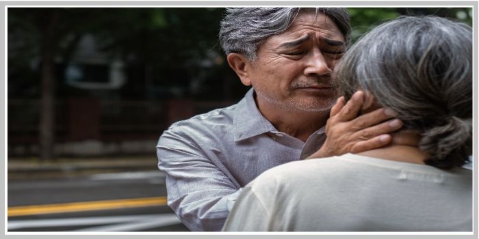 기억을 잃은 듯한 아내를 애틋하게 바라보며 얼굴을 감싸는 중년 남성의 실제 사진