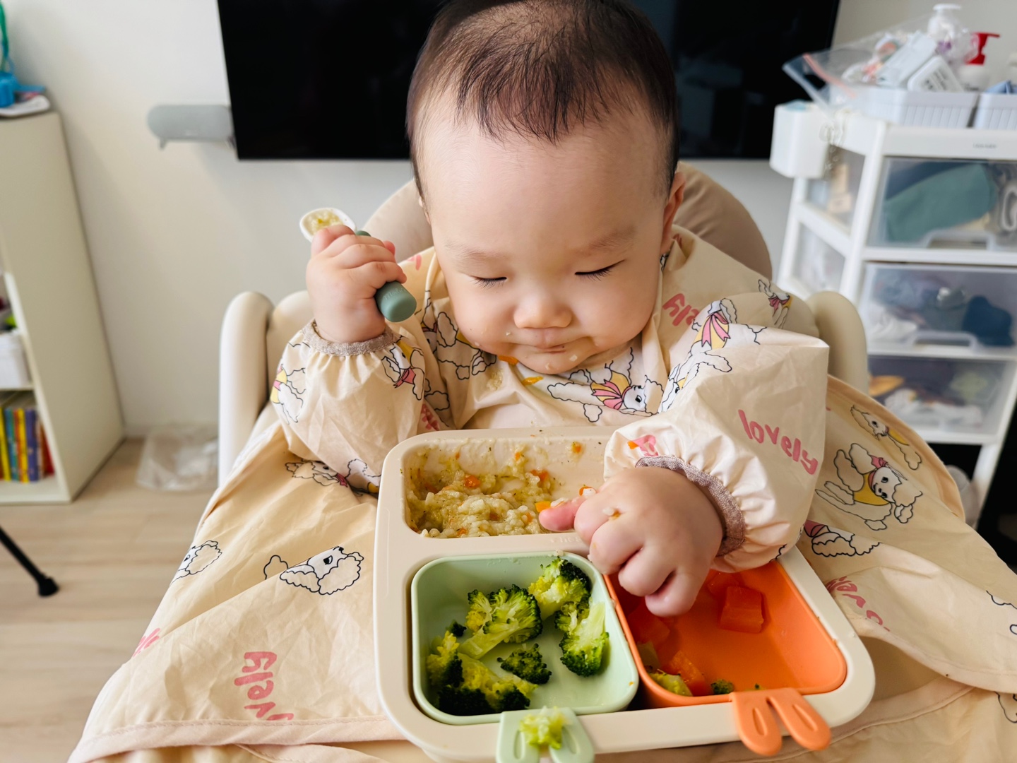 브로콜리와 당근을 손으로 만지며 관찰하는 아기