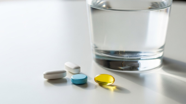 탈모 치료제 알약과 물컵이 놓인 책상 장면