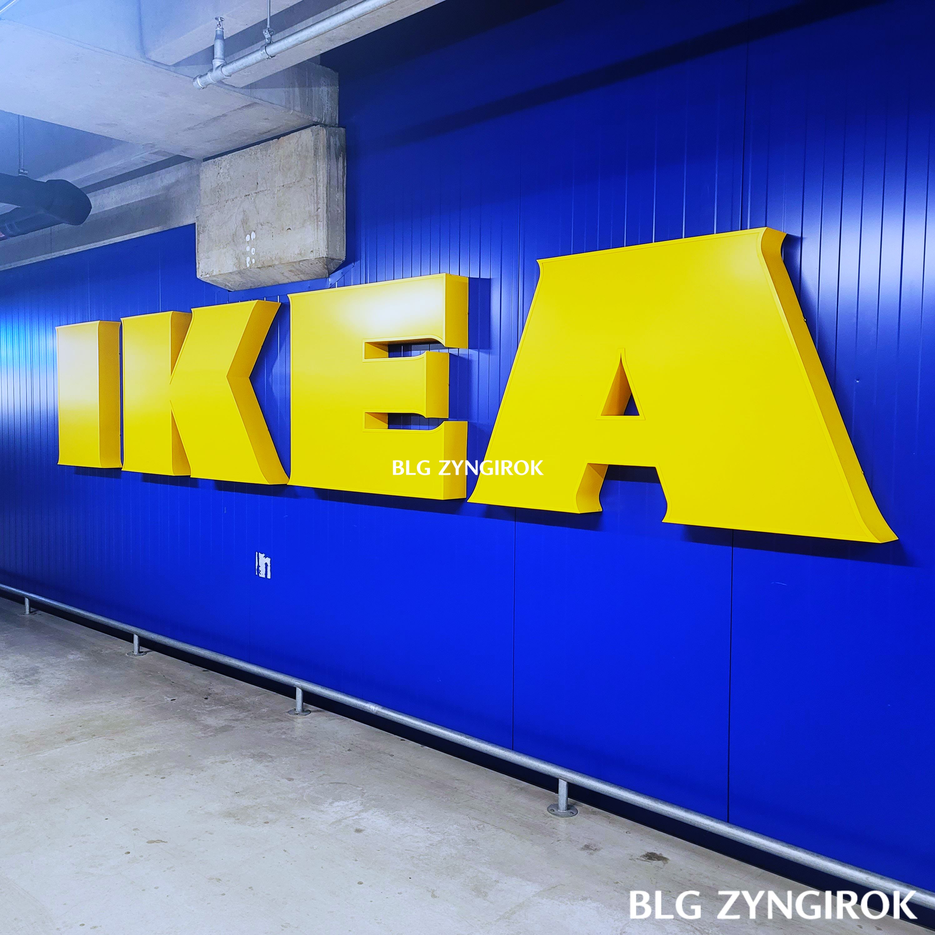 지하-주차장에-걸려있는-이케아-글씨-간판이다.-파란-벽면에-노란색의-입체-이케아-글씨가-걸려있다.