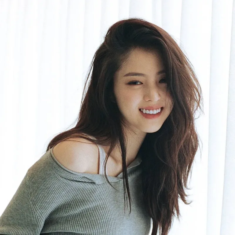 긴 갈색 웨이브 머리로 웃고 있는 배우 한소희 프로필 썸네일
