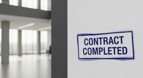 벽면에 &lsquo;계약 완료&rsquo; 도장이 찍힌 종이 붙은 장면