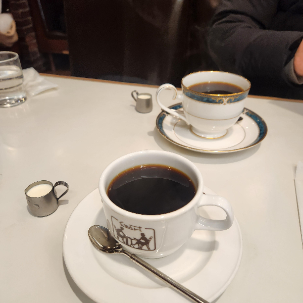 클래식한 커피잔에 담긴 커피와 연유