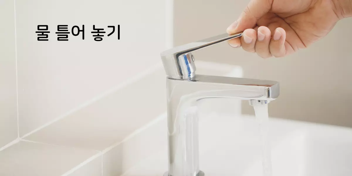 물 화장실 내 수도꼭지에 물이 틀어져 있다