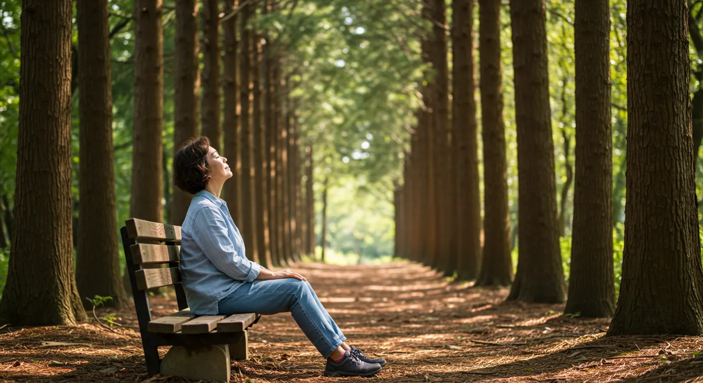 숲길벤치에 앉아 평화로운 표정으로 눈을감고 자연을 느끼고있는 중년여성