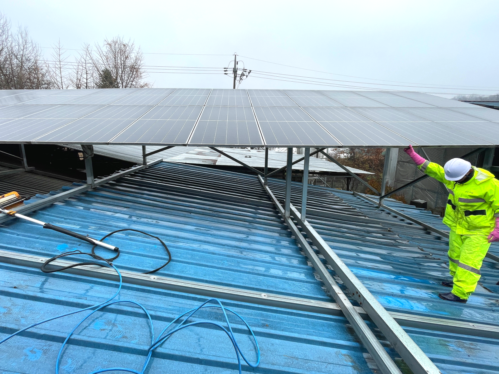 파란 지붕 위 녹색옷을 입은 작업자