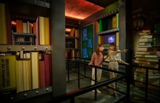 어두운 실내 공간에 여성 두 명이 서 있다.