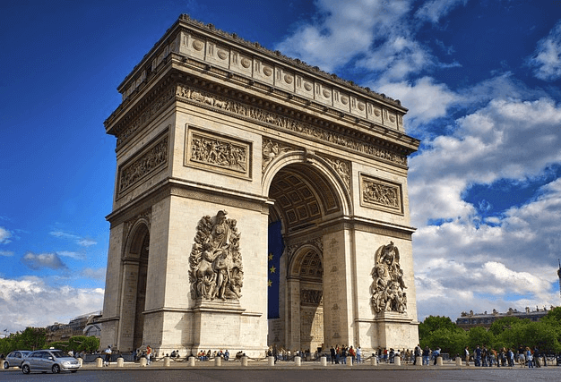 프랑스 파리에 있는 개선문이다. 네모난 건물이며 가운데 입구로 사람들이 지나간다.