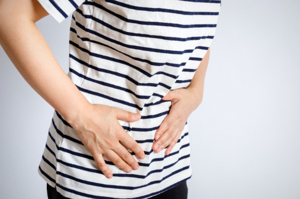 장염으로 배가 아파 배를 만지고 있는 사람