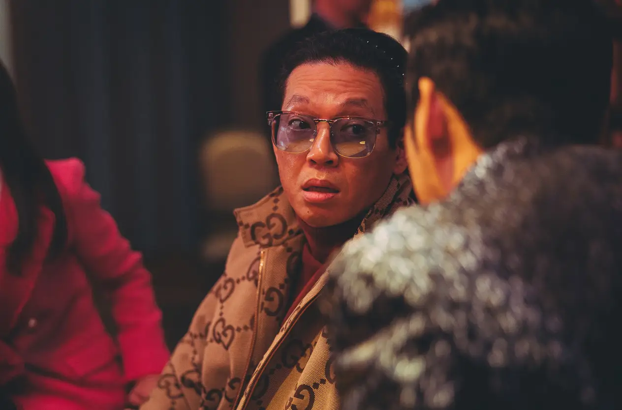 범죄도시-갈색 쟈켓을 입고 의자에 비스듬이 앉아 옆사람을 바라보는 장이수