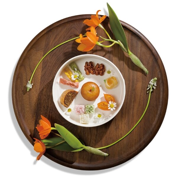 쟁반위에 놓인 주황색 꽃과 다과가 담긴 접시