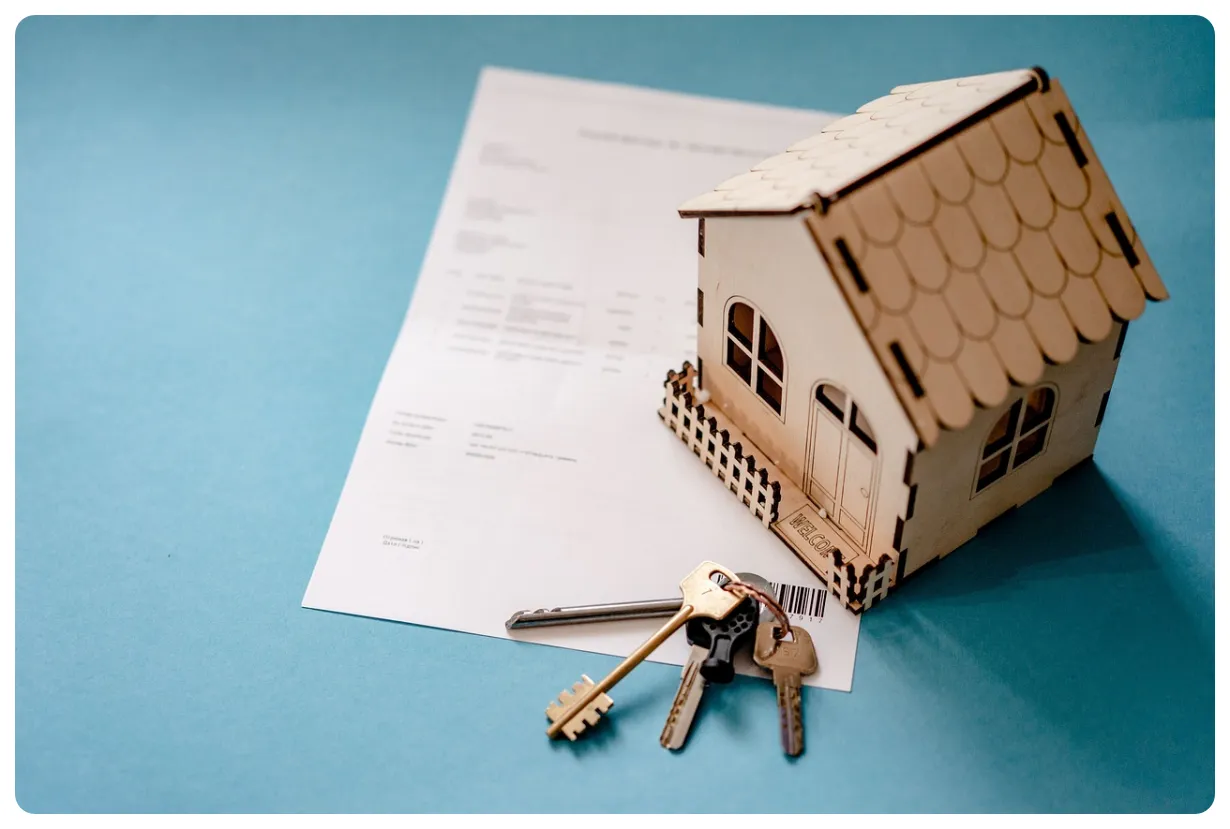 서류-위에-작은집과-열쇠-뭉치가-놓여있음