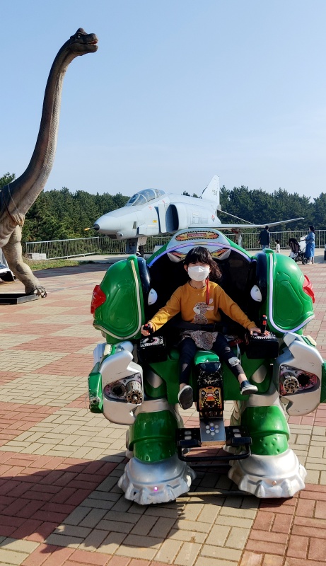 로봇 놀이 기구를 타고 해맑게 웃는 쿠앙이