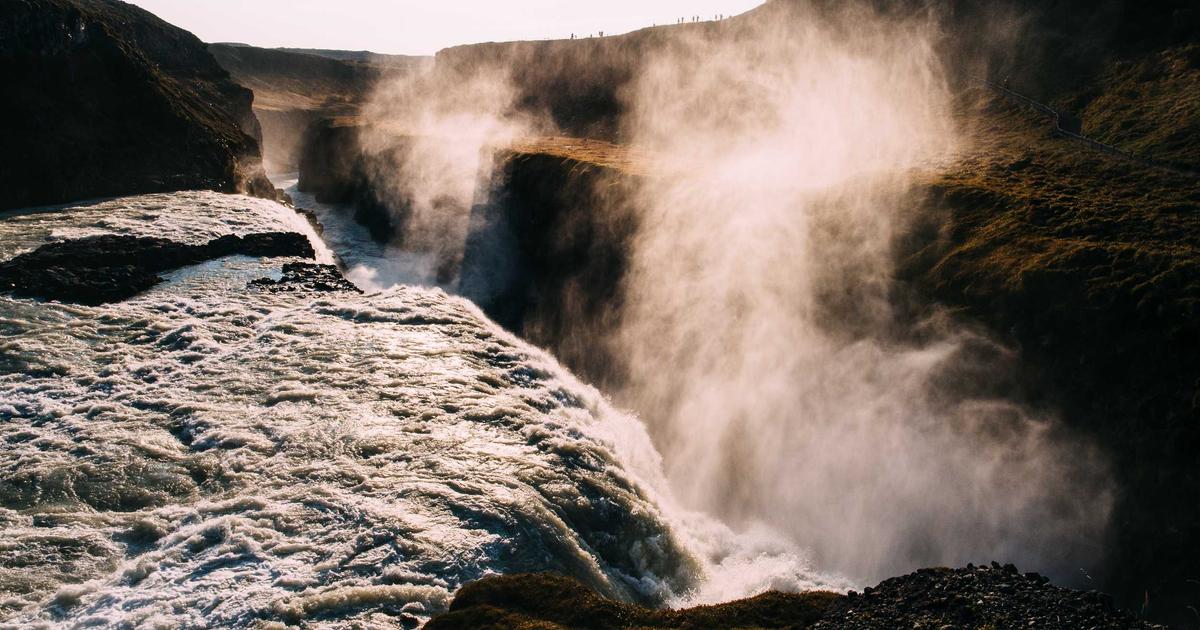 person happily writing at computer with AI assistant on screen, coffee cup, bright desk