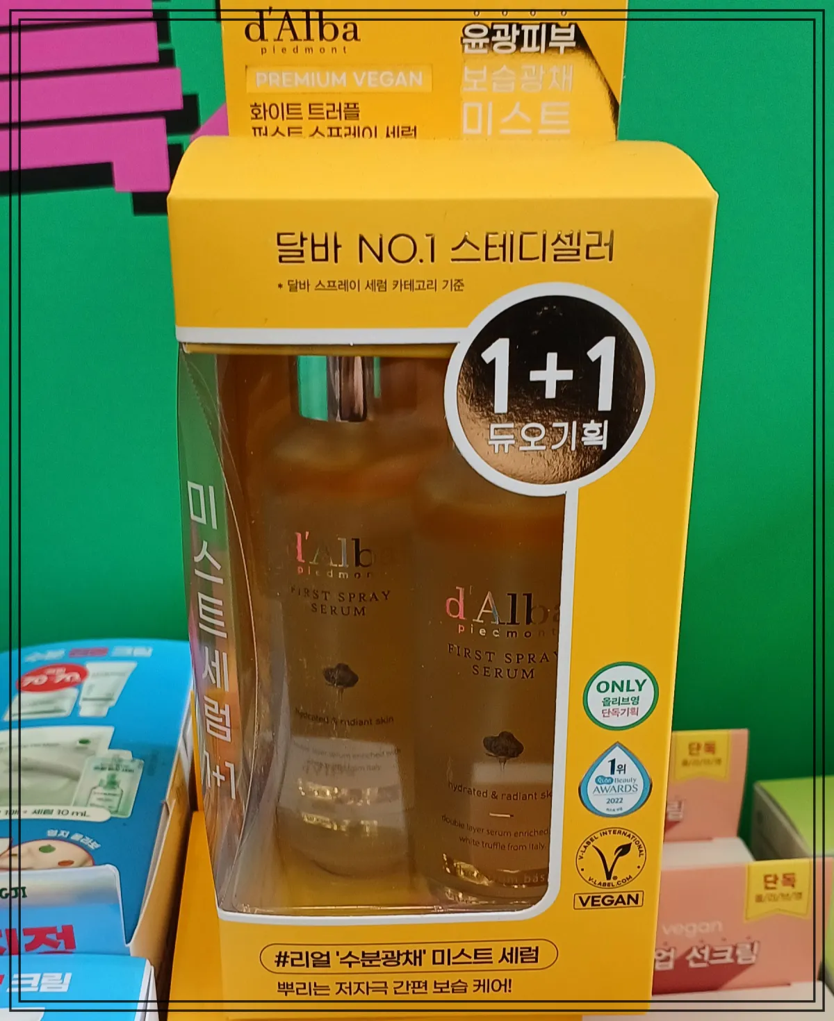 올리브영-매장-선반에-전시된-달바-미스트-세럼-1-플러스-1-기획-세트-패키지-노란색-박스-안에-두-병이-들어-있음