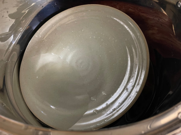 곰솥 안에 누름돌과 도자기 접시 담기