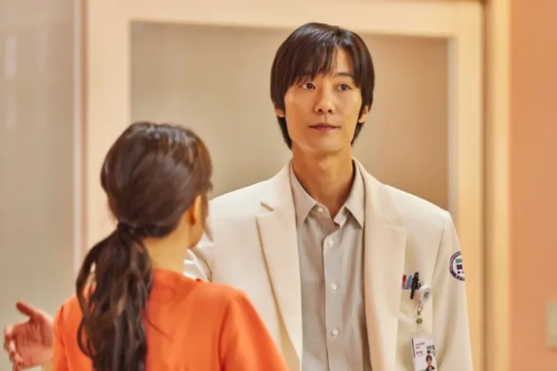 병원을 배경으로 흰 의사 가운을 입고 서 있는 드라마 정신병동에도 아침이 와요의 황여환 캐릭터