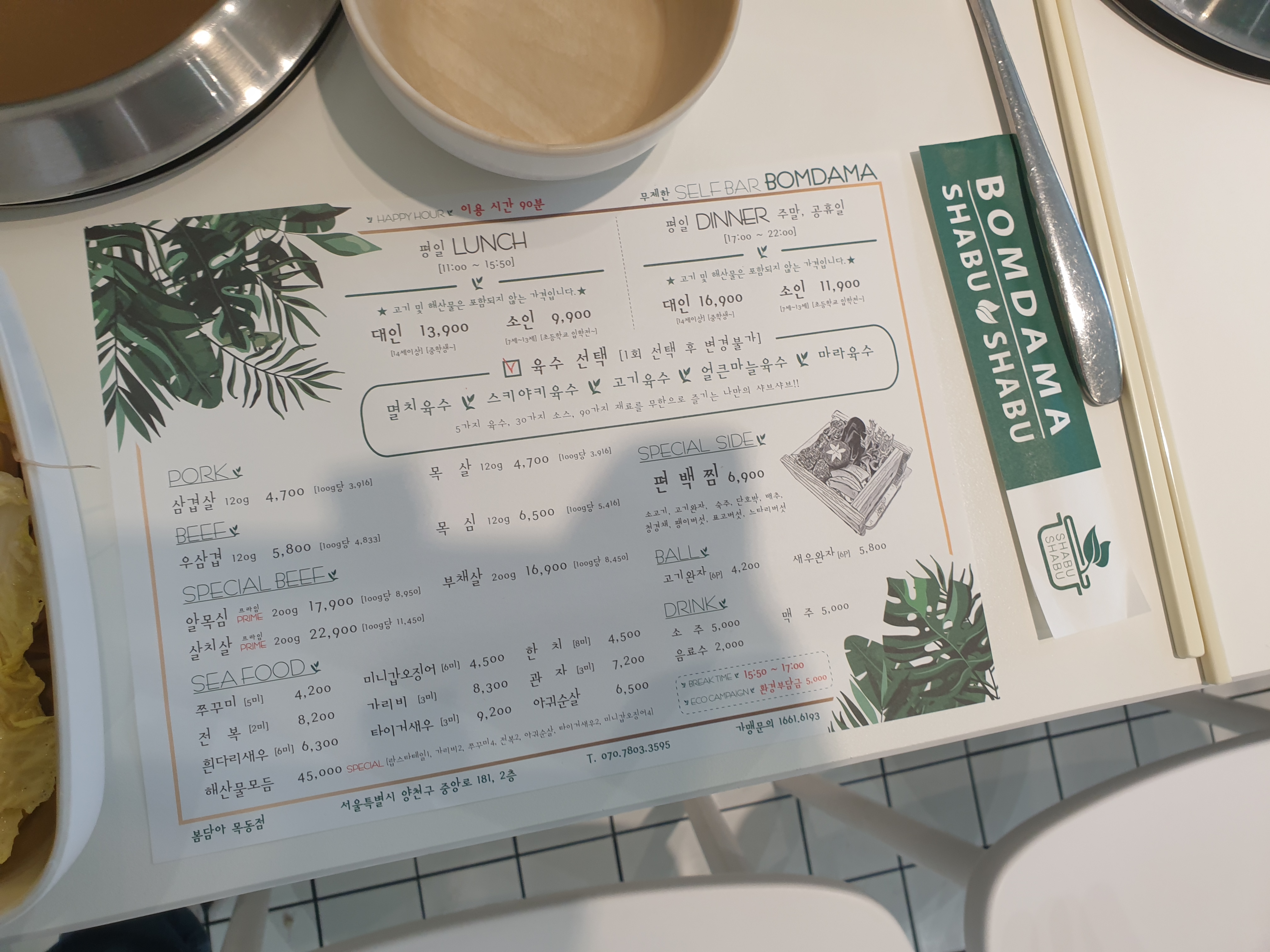 바닥에 메뉴판이 놓여있다. 초록색 글씨로 된 메뉴판