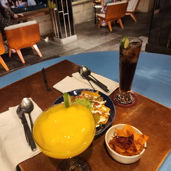 나초와 칵테일 두잔 하나의 칵테일은 콜라가 들어간 것 다른 하나는 망고 슬러시가 올라가 있다.