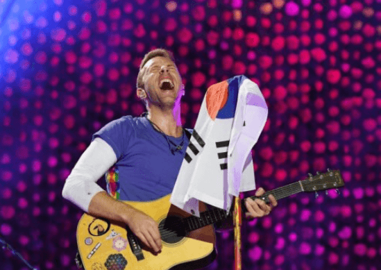 태극기를-마이크에-걸고-기타를-연주중인-콜드플레이-보컬