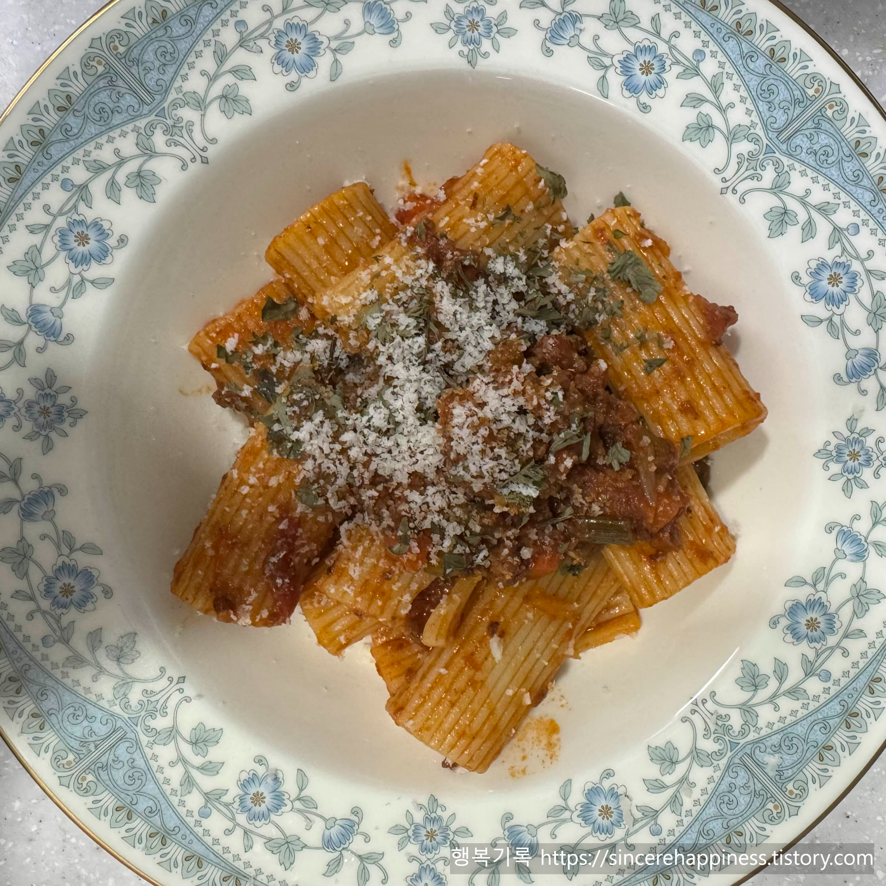 완성된 라구소스에 면을 버무리고 치즈를 갈아 올린 파스타 플레이팅