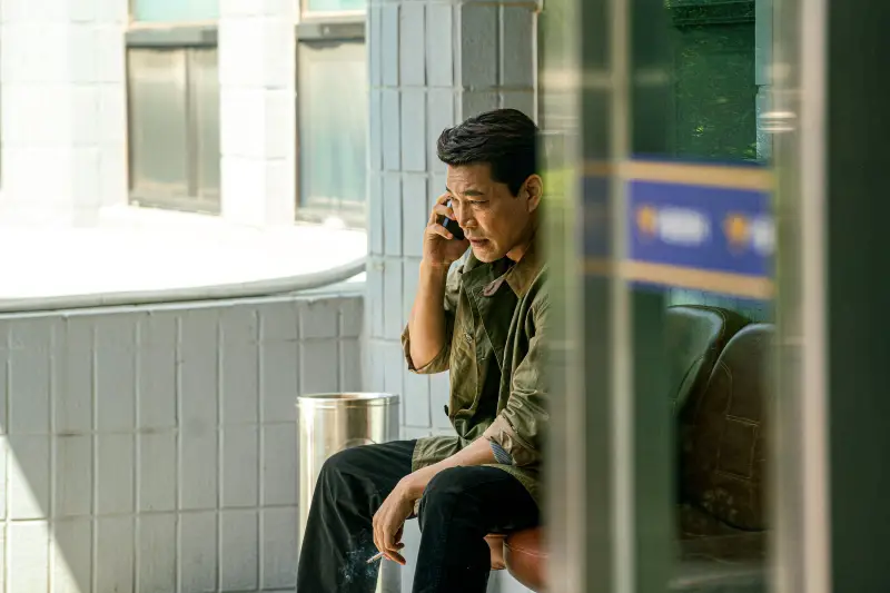 한 건물 테라스에 앉아서 한손에 담배와 다른 한손에는 전화하고 있는 강력계 형사 팀장