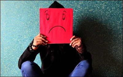 슬픈 표정의 카드를 들고 있는 사람