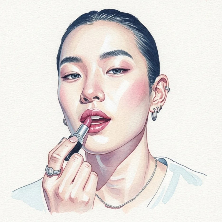 쿨톤 피부에 립스틱을 바르며 미소 짓는 사람