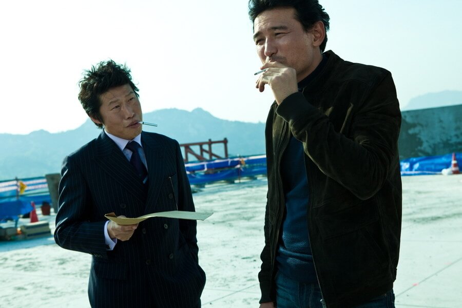 빌딩 옥상에서 담배피며 이야기하는 최철기와 장석구