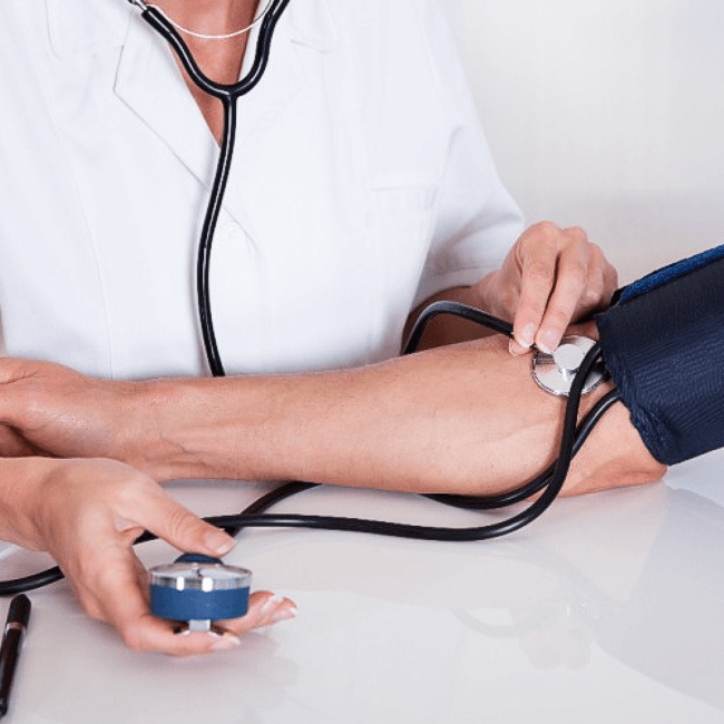 의사가 혈압을 재면서 청진기로 진료 중인 모습